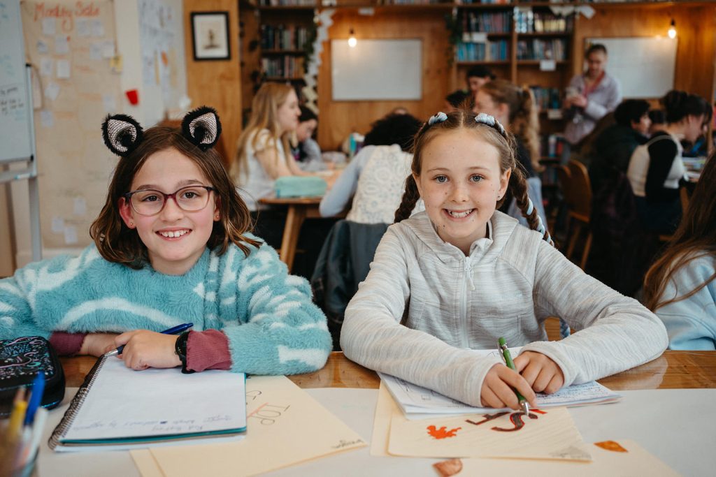 creative writing class in melbourne two primary aged girls writing in notebooks at story studios school holiday program in Melbourne