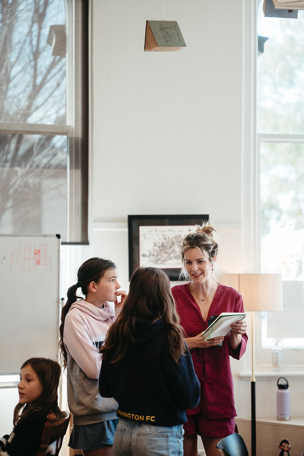 Story mentor discussing a notebook with young writers